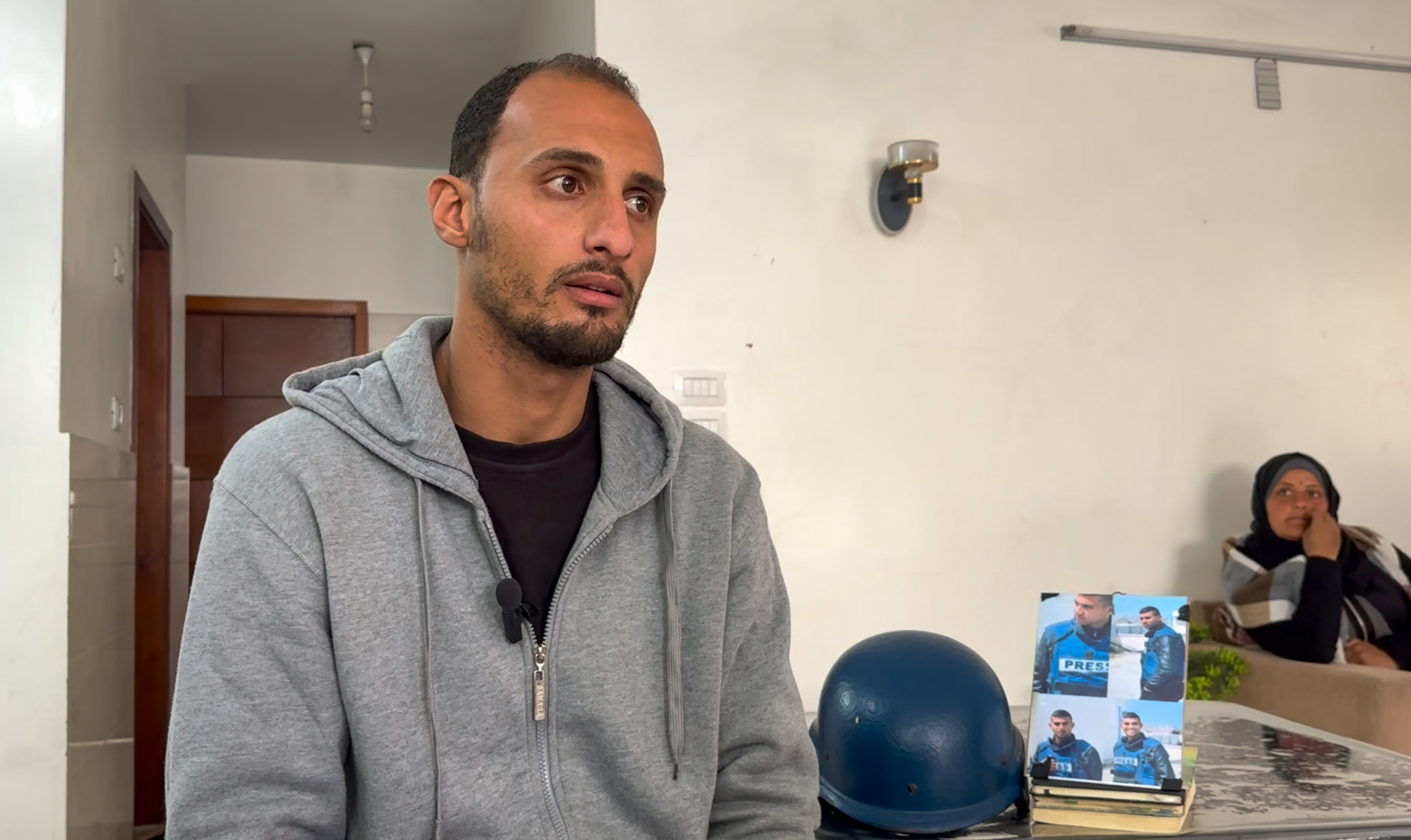 Mahmoud Shabat, slim, with stubble and wearing a grey sweatshirt. His eyes are red from crying